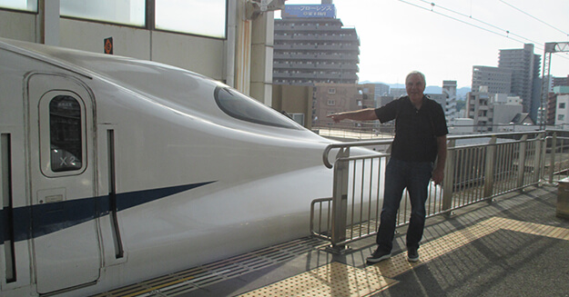 Jim Geiger posing with a bullet train in Japan