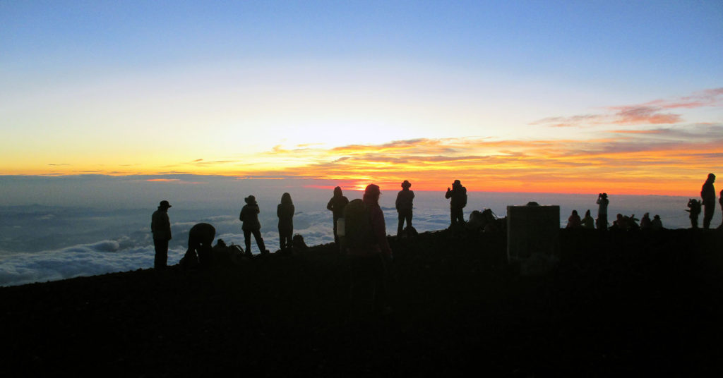 Jim Geiger and other climbers enjoy the sunrise atop Mt. Fuji after an early-morning climb
